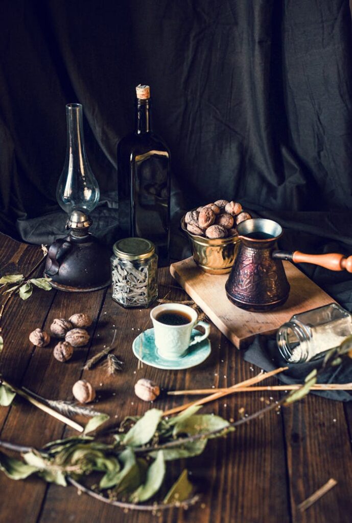 Coffee cup and pot with walnuts bowl placed on table with various spices and retro decorations